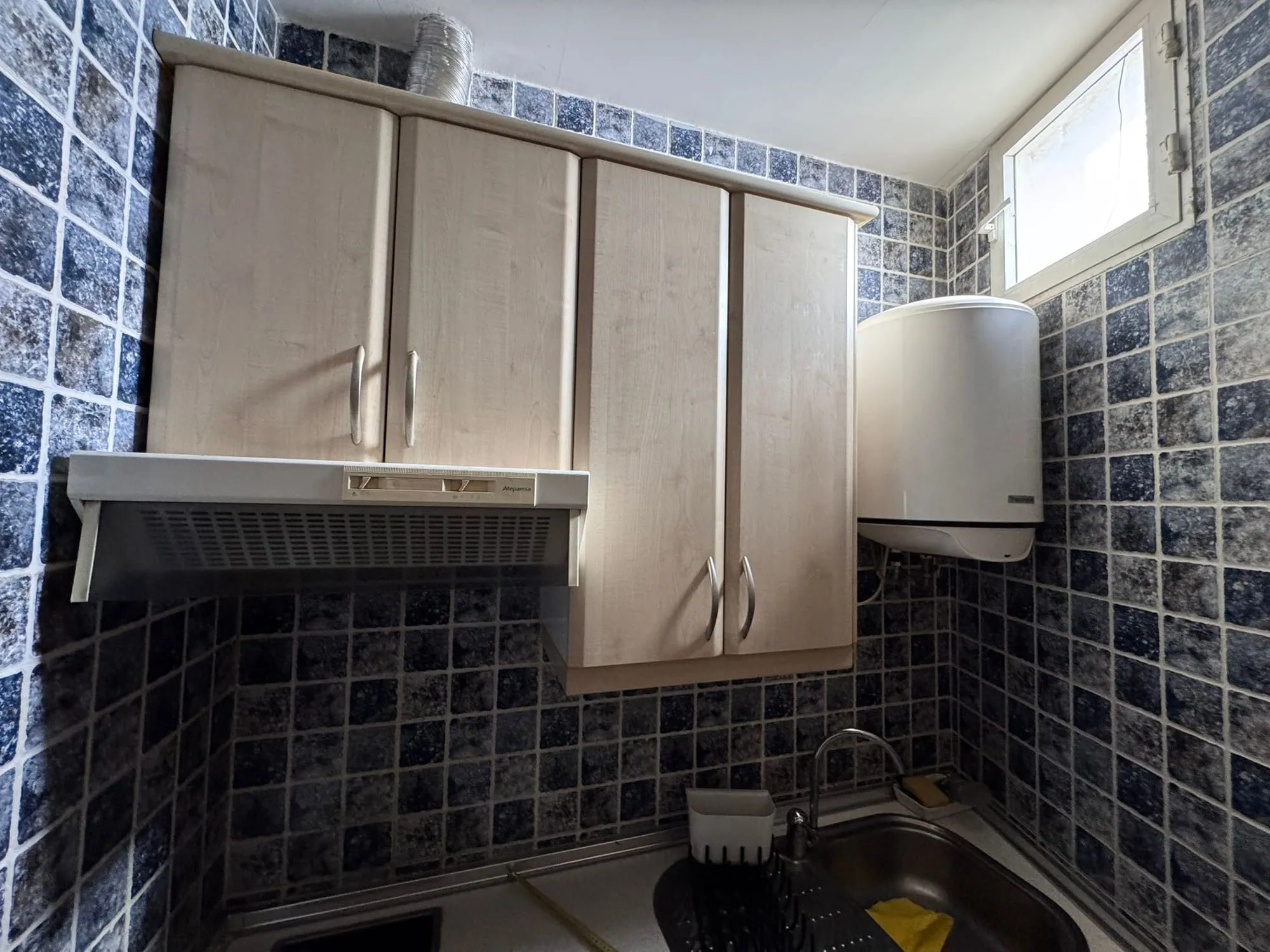 La cocina antes de la reforma, con muebles y azulejos antiguos