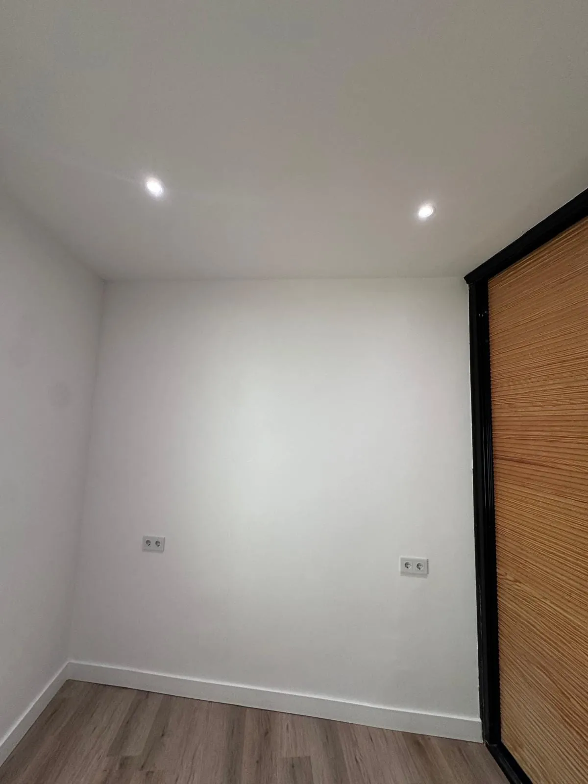 Habitación terminada con rodapié blanco y enchufes nuevos
